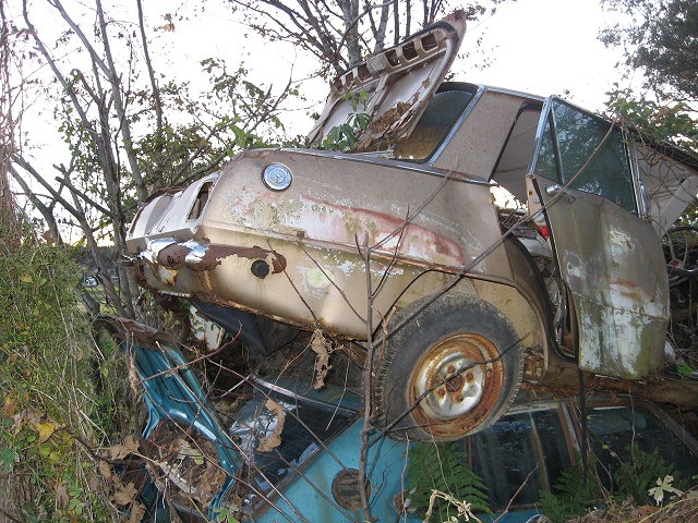 Isuzu Bellet sitting on top of a Nissan Laurel C230