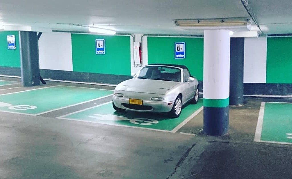 The third time I spotted this Mazda Miata NA hogging an EV charging spot